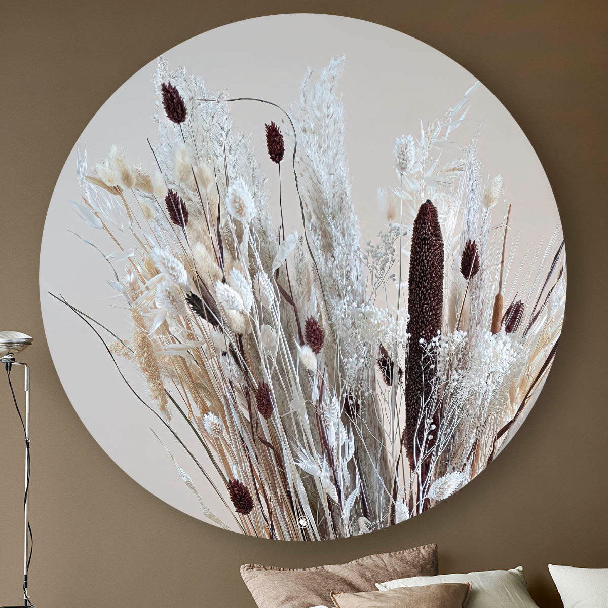Wandcirkel met droogbloemen in lichte kleuren gemixt met bruin tegen een beige muur