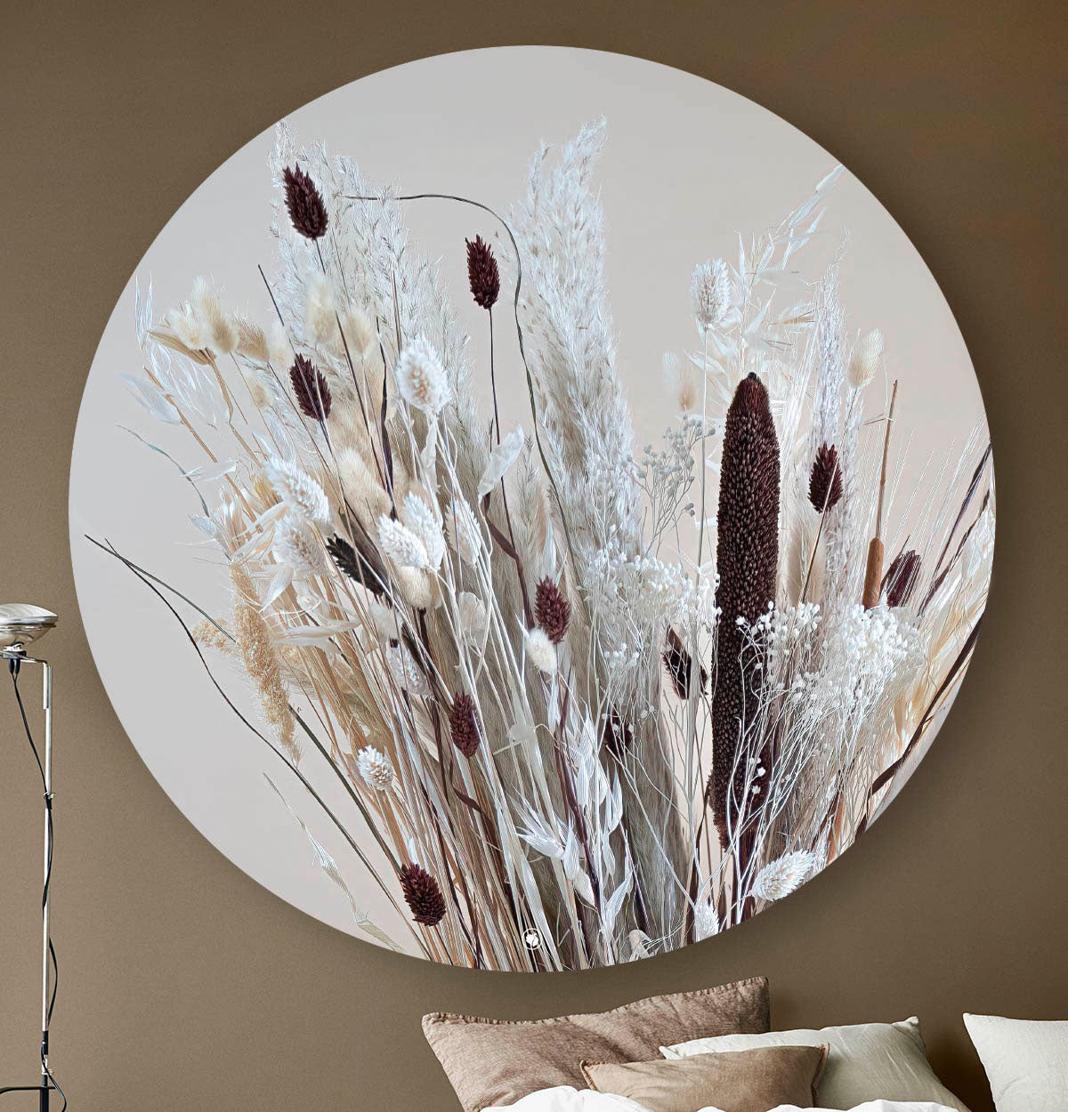 Wandcirkel met droogbloemen in lichte kleuren gemixt met bruin tegen een beige muur