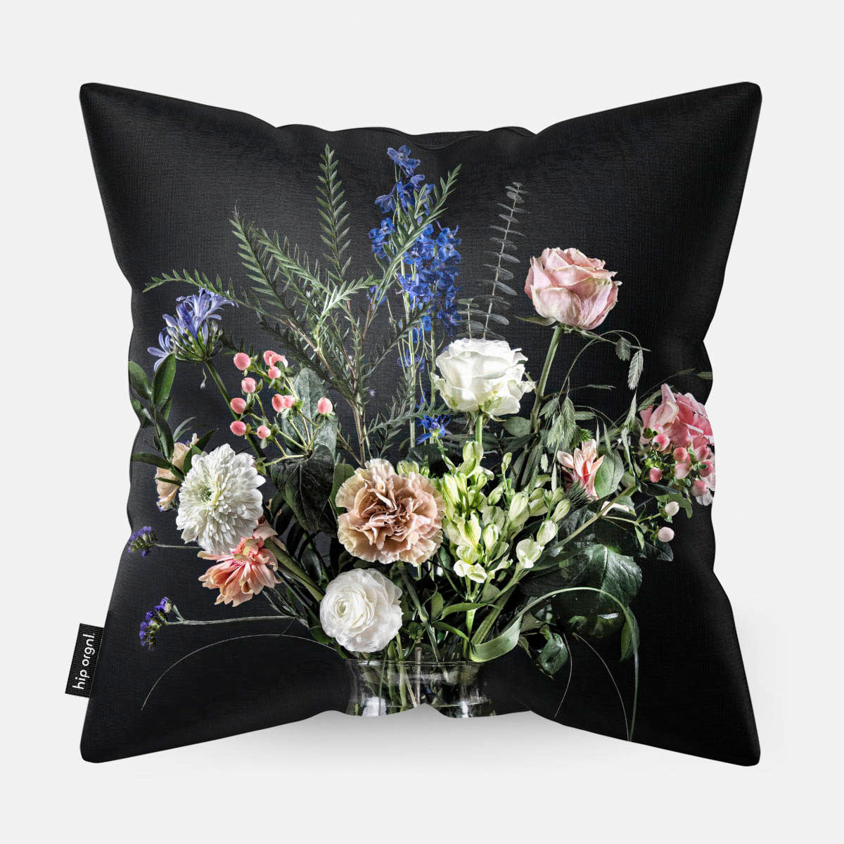 Achterzijde van een sierkussen met bloemen in een glazen vaas met zwarte achtergrond