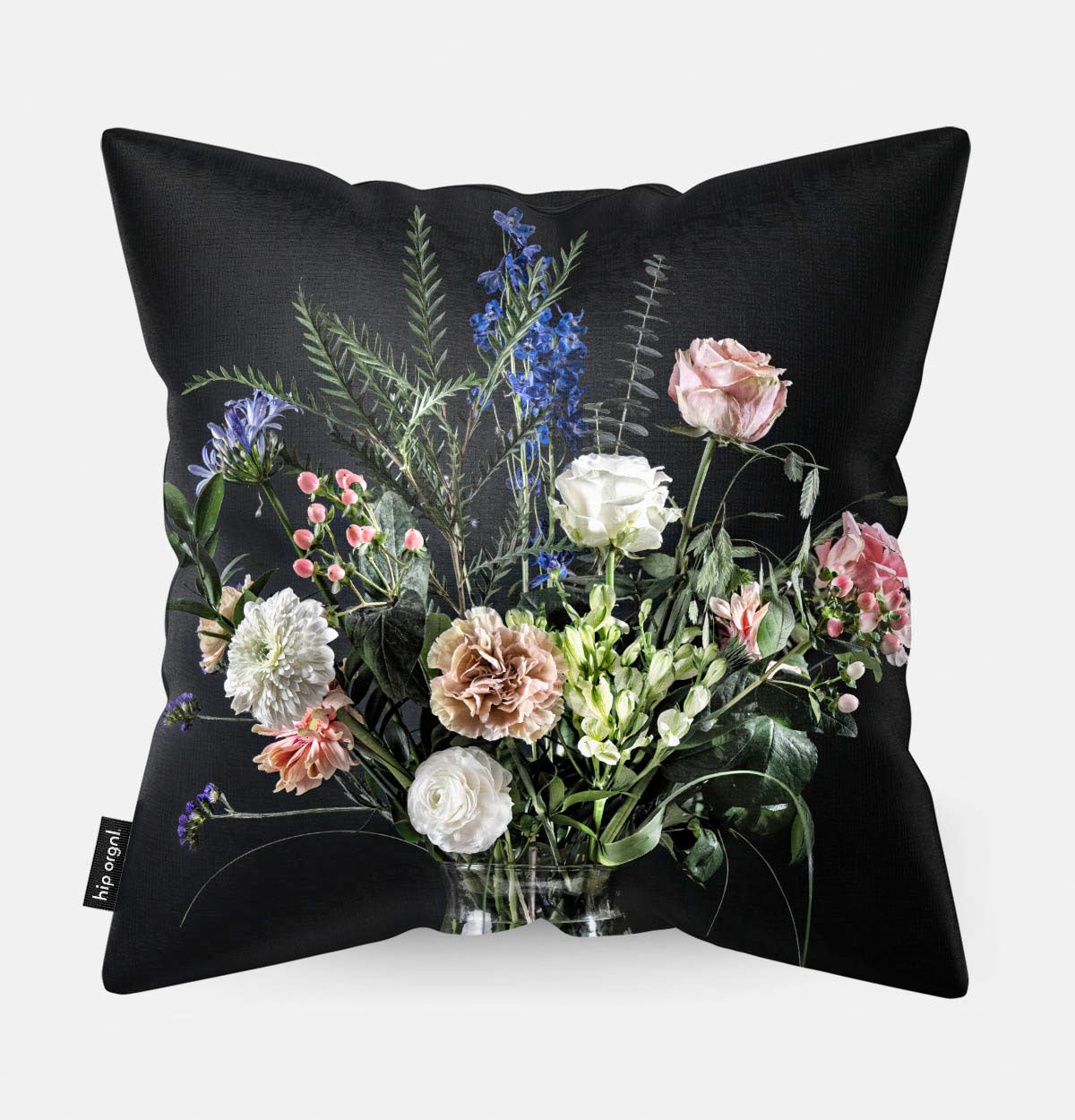 Achterzijde van een sierkussen met bloemen in een glazen vaas met zwarte achtergrond