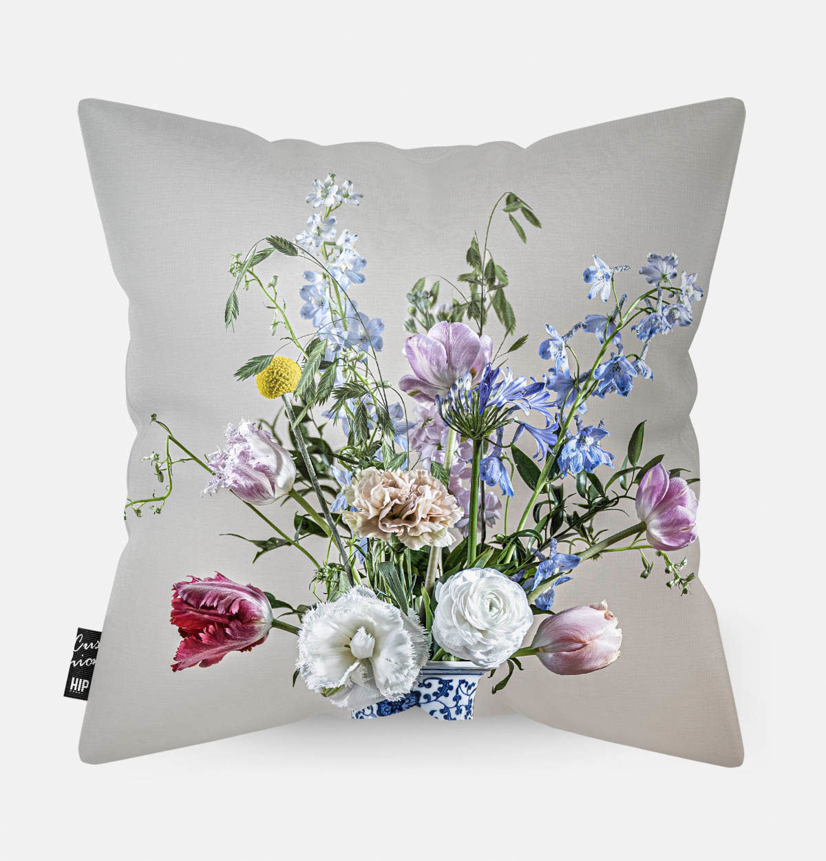 Achterzijde van een sierkussen met bloemen met een lichte achtergrond