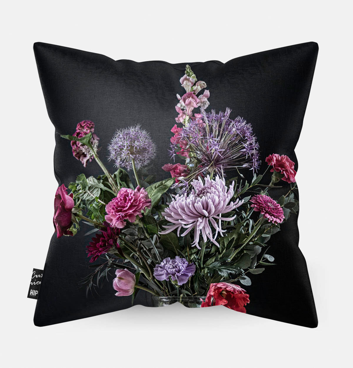 Achterzijde van een sierkussen met rode en paarse bloemen met een zwarte achtergrond