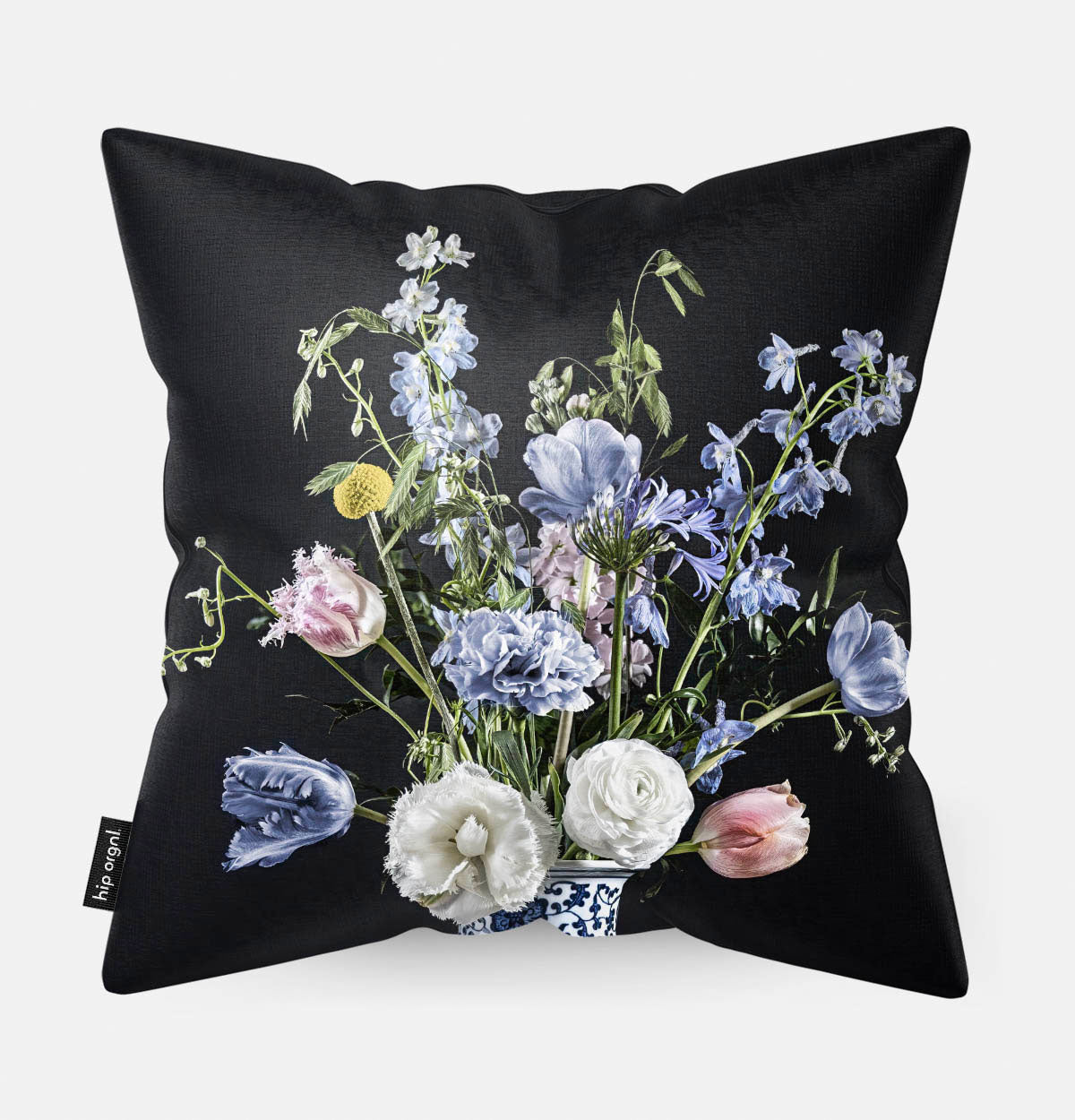 Achterzijde van een sierkussen met lichtblauwe en witte bloemen met een donkere achtergrond