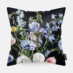Voorzijde van een sierkussen met licht blauwe en witte bloemen met een donkere achtergrond