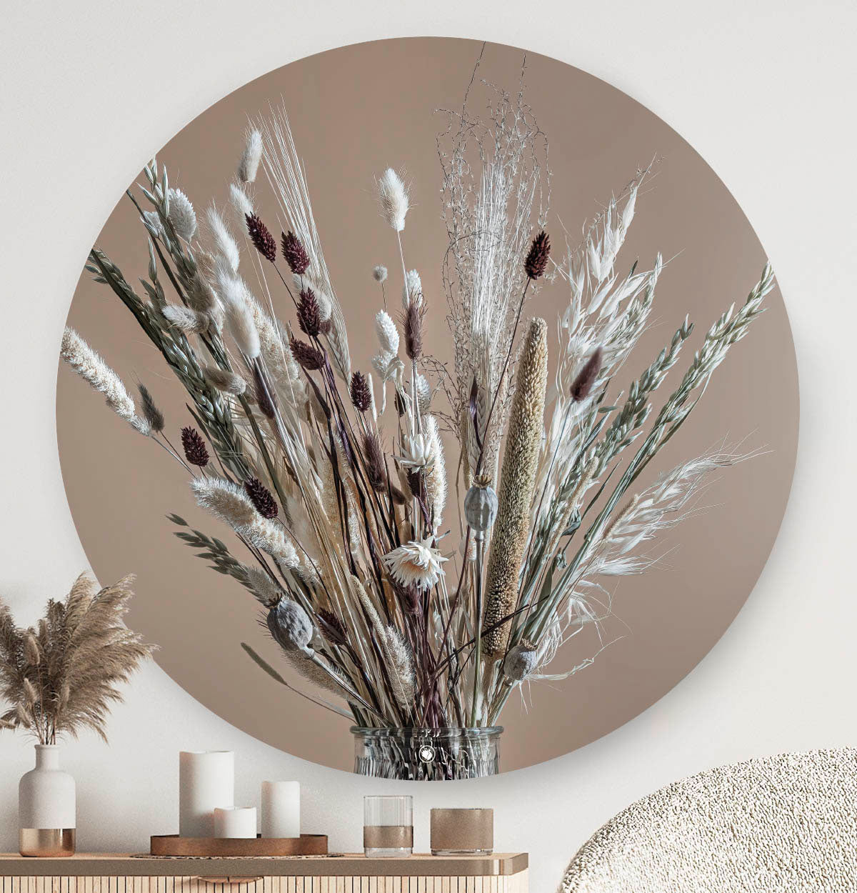 Wandcirkel met witte en bruine droogbloemen in een glazen vaas tegen een witte muur