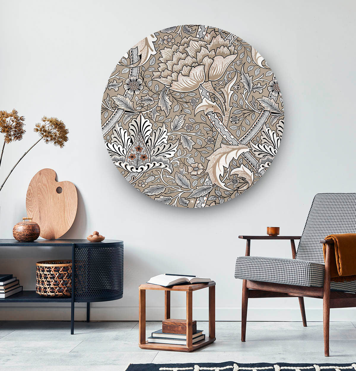 Wandcirkel met bloemenpatroon tegen een witte muur en een zwart dressoit en houten stoel