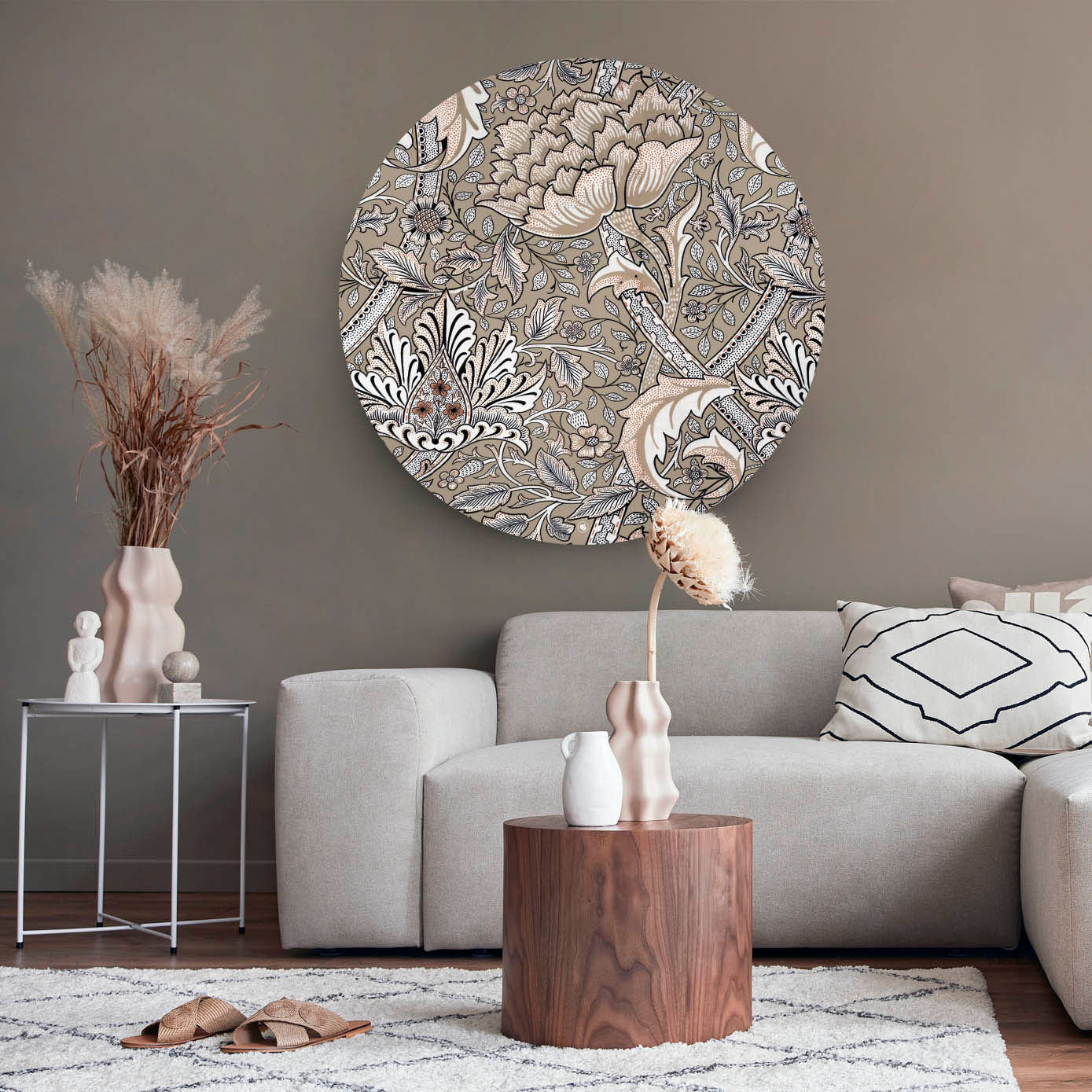 Muurcirkel met een bloemenpatroon tegen een muur met een lichte bank en houten tafel