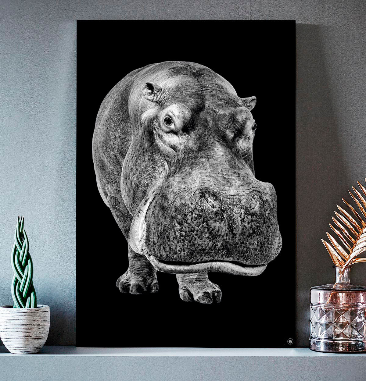Vierkante wanddecoratie met nijlpaard erop.