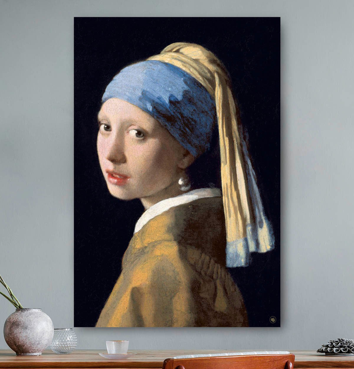 Vierkante wanddecoratie met schilderij van meisje met de parel erop.