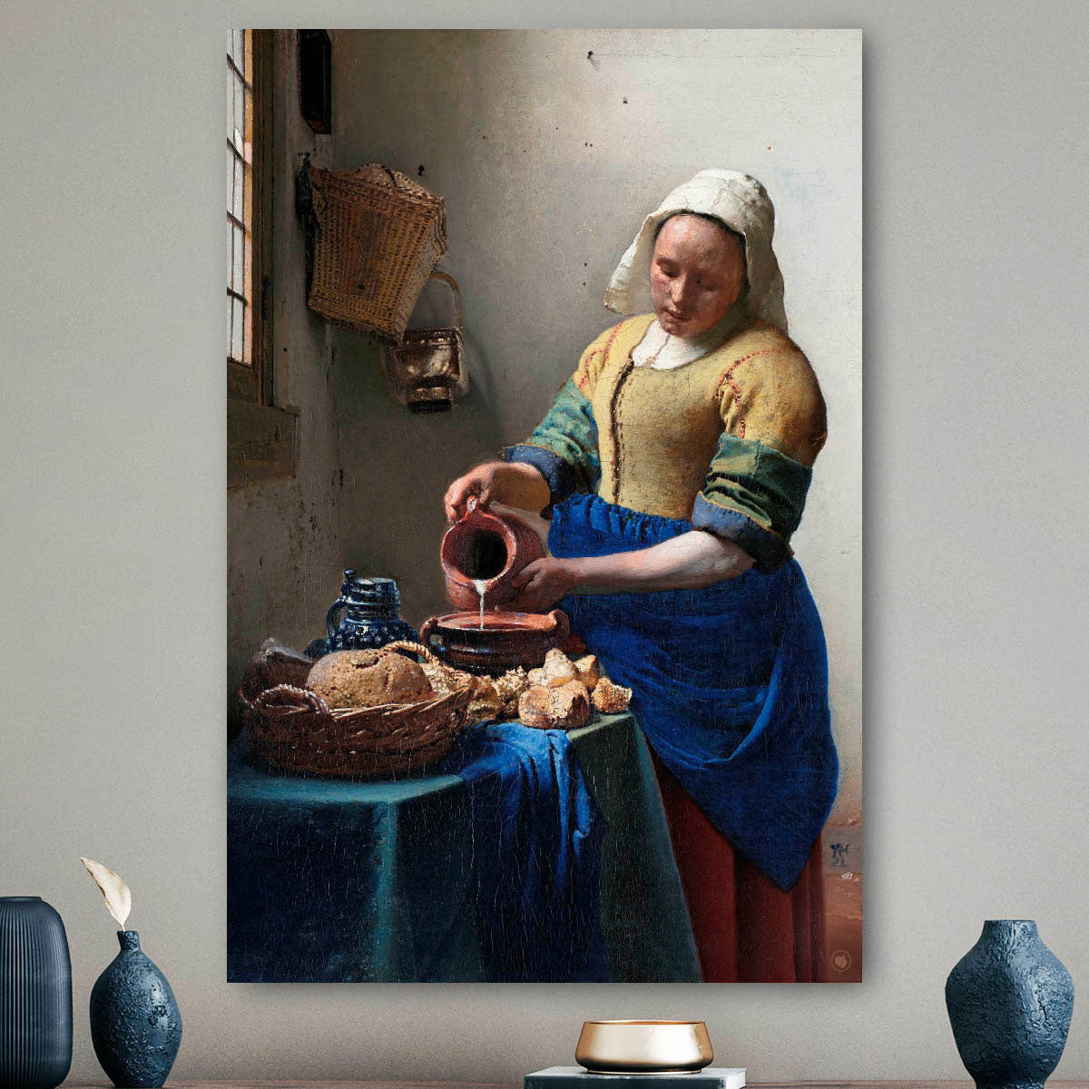 Vierkante wanddecoratie met het melkmeisje erop.