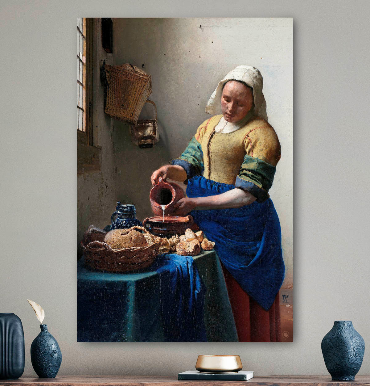 Vierkante wanddecoratie met het melkmeisje erop.