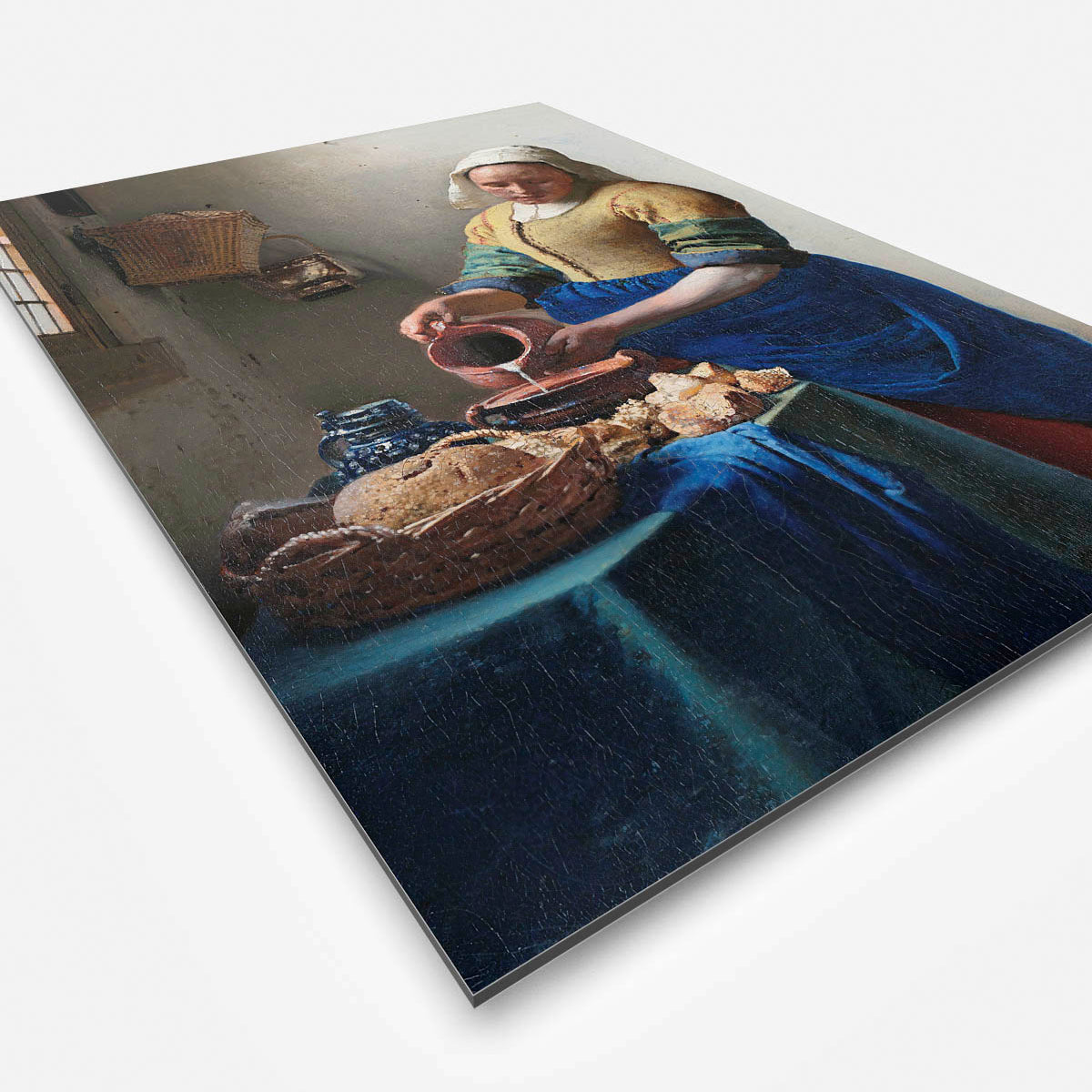 Vierkante wanddecoratie met het melkmeisje erop.