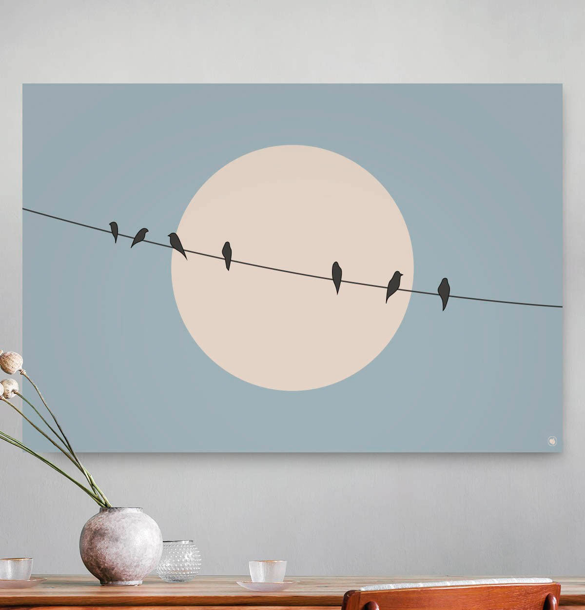 Vierkante wanddecoratie met vogels op een draad met de zon op de achtergrond erop.