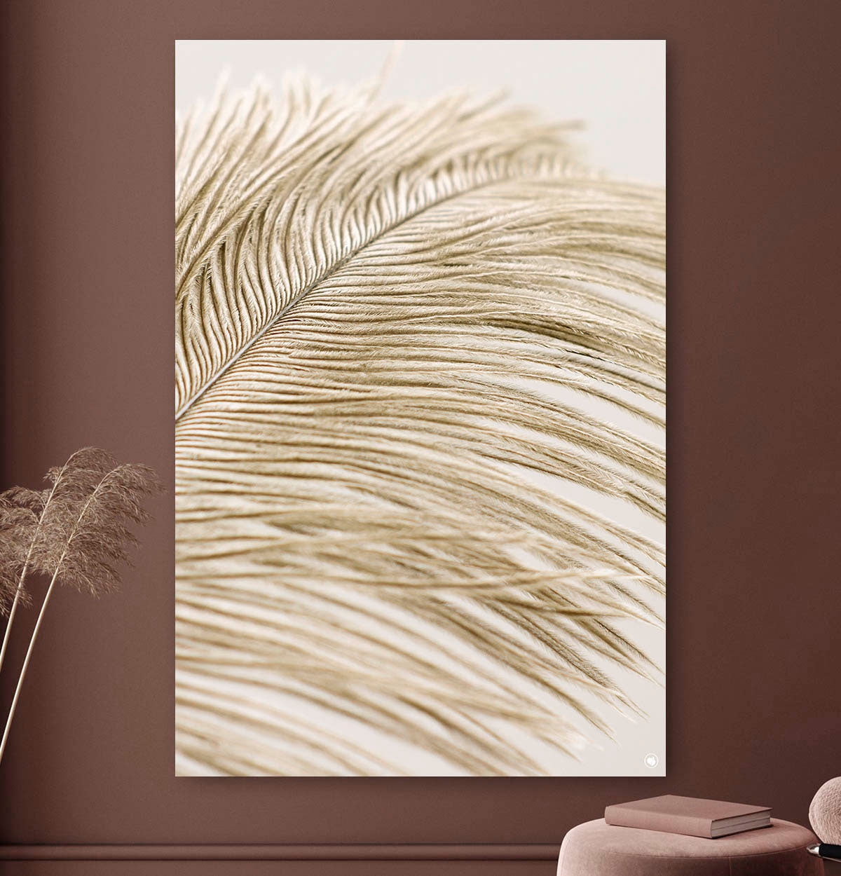 Vierkante wanddecoratie met veer van een struisvogel erop.
