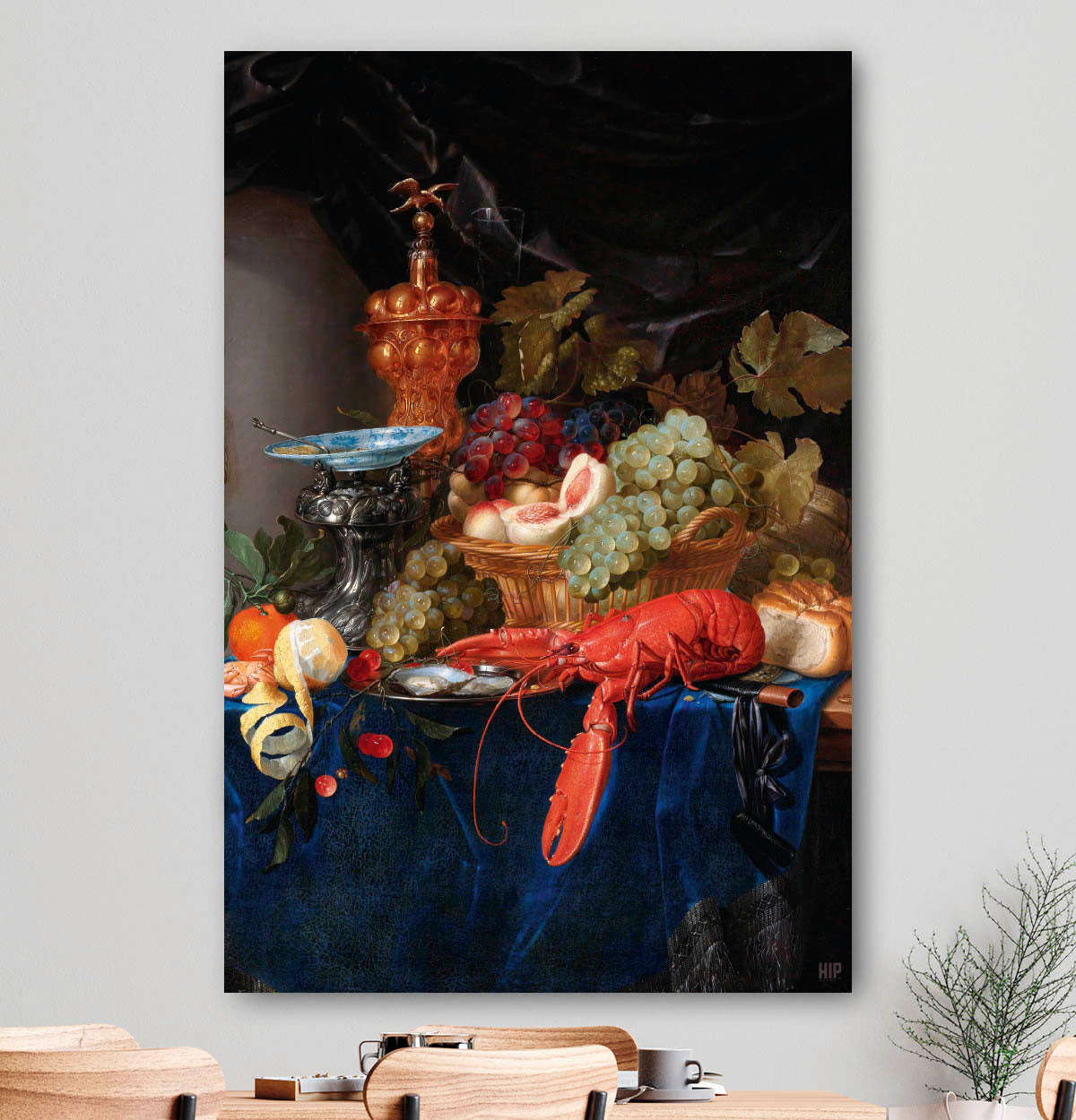 Vierkante wanddecoratie met stilleven met een gouden bokaal erop.
