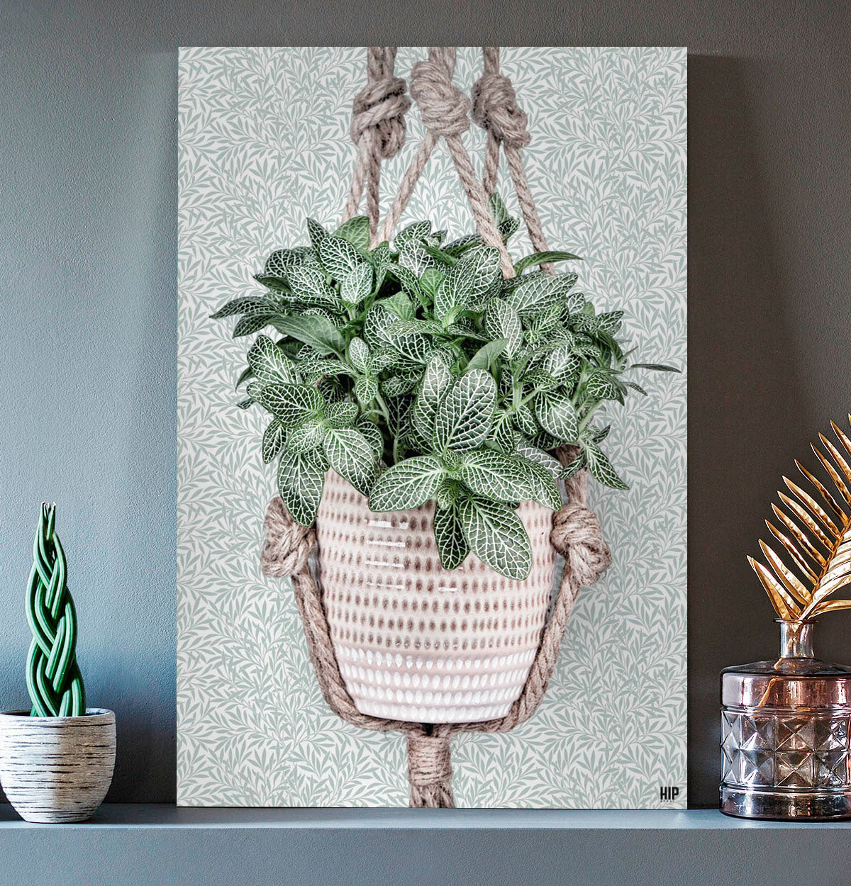 Vierkante wanddecoratie van een hangplant erop.