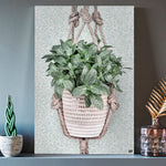 Vierkante wanddecoratie van een hangplant erop.