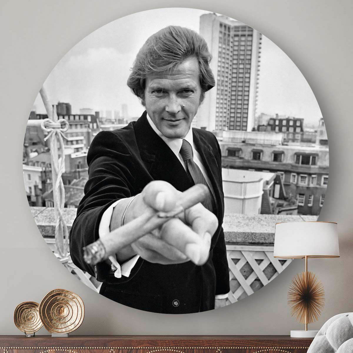 Bruin dressoir met een wandcirkel aan de muur met daarop Roger Moore met een sigaar in zijn hand