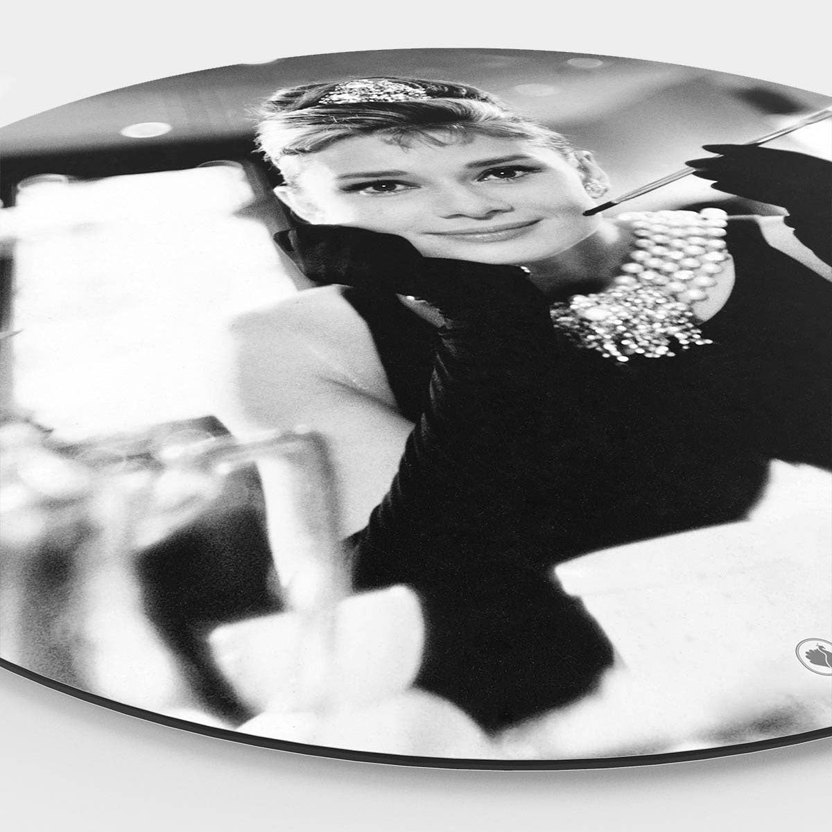 Zijkant van een muurcirkel met daarop Audrey Hepburn met een sigaret in haar hand aan het ontbijt.