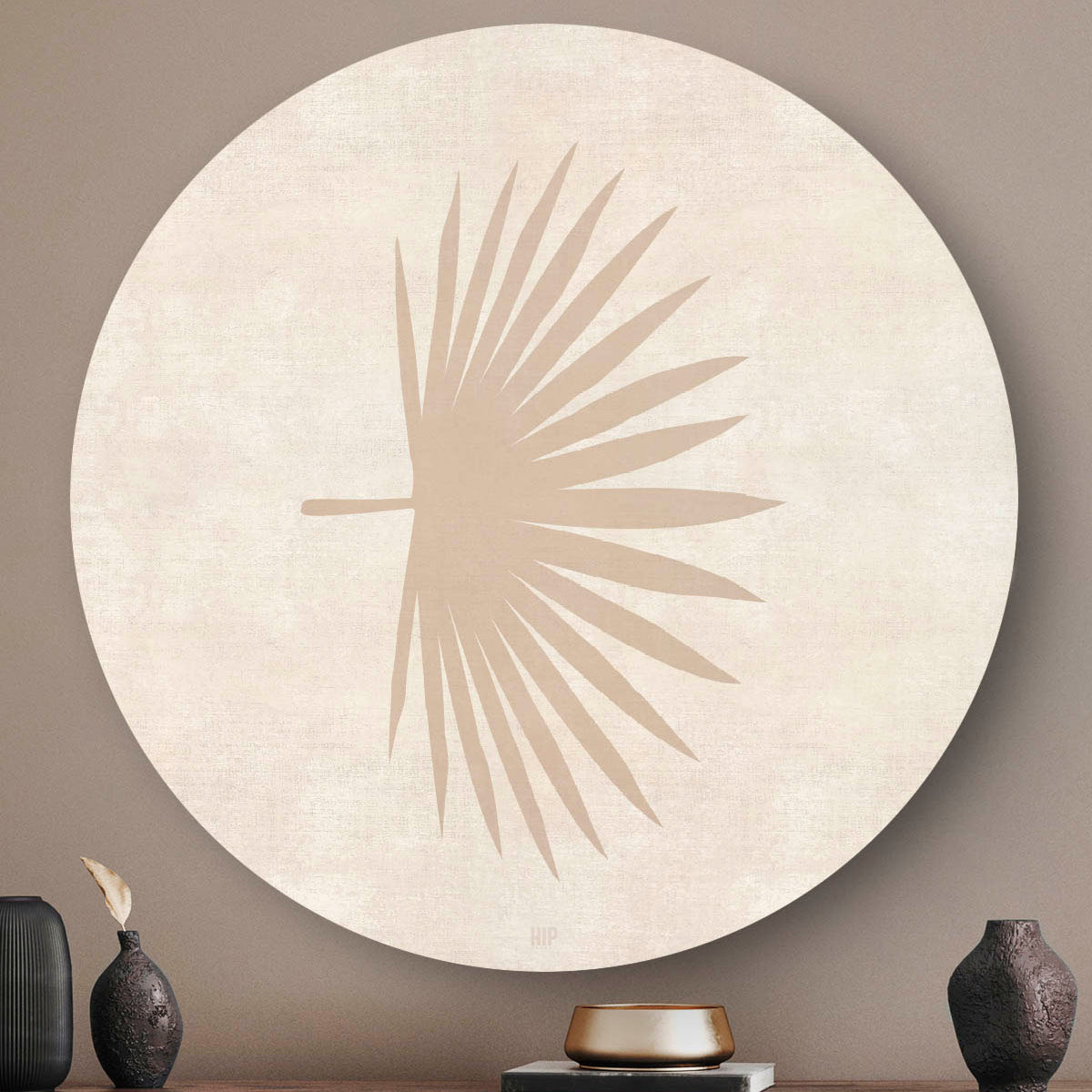 Wandcirkel met een abstract palmblad en een lichte achtergrond boven een houten dressoir