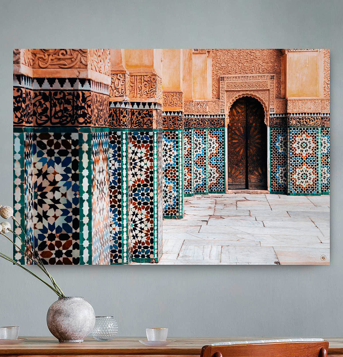 Vierkante wanddecoratie met een gebouw in Marrakesh erop afgebeeld.