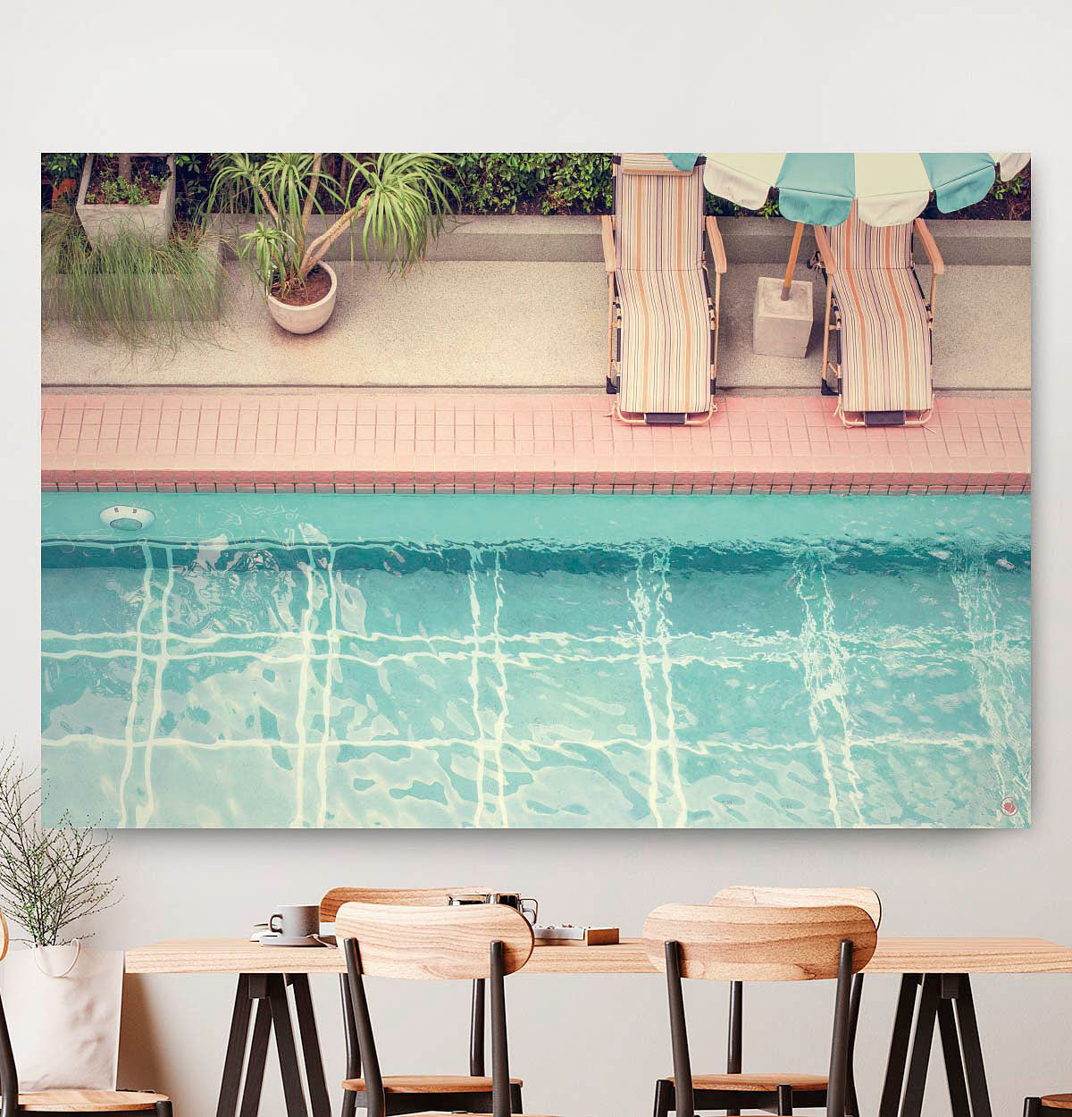 Vierkante wanddecoratie van een zwembad met bedden aan de rand.