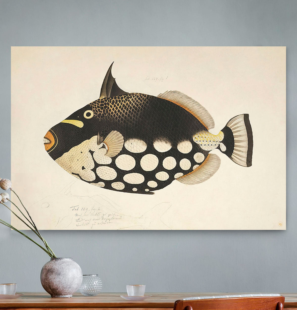 Schilderij met een zwart bruine vis tegen een grijze muur met een vaas er voor