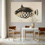 Schilderij met een zwart bruine vis tegen een muur met stoelen en een tafel er voor