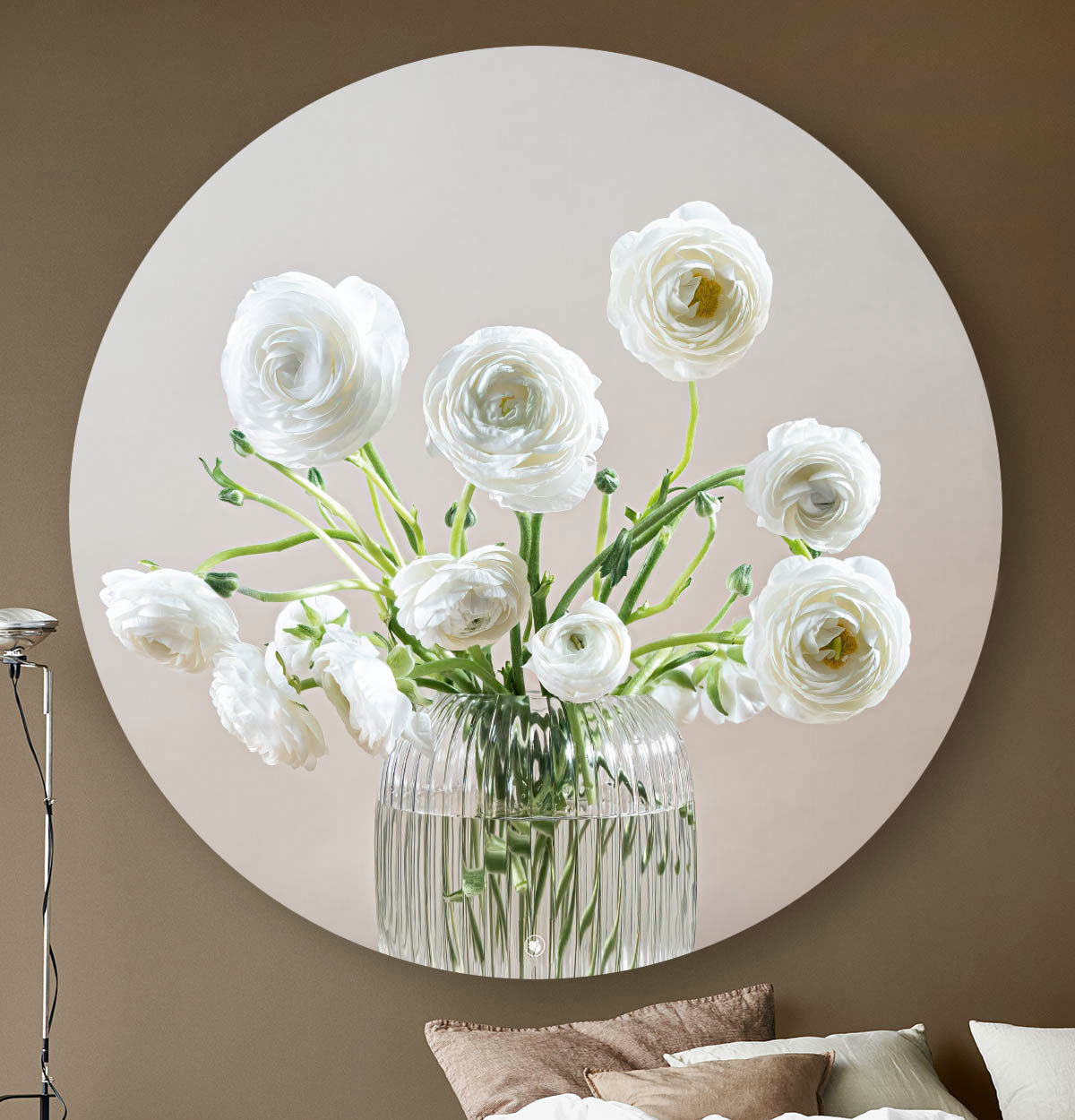 Wandcirkel met een glazen vaas met witte bloemen tegen een donkere muur