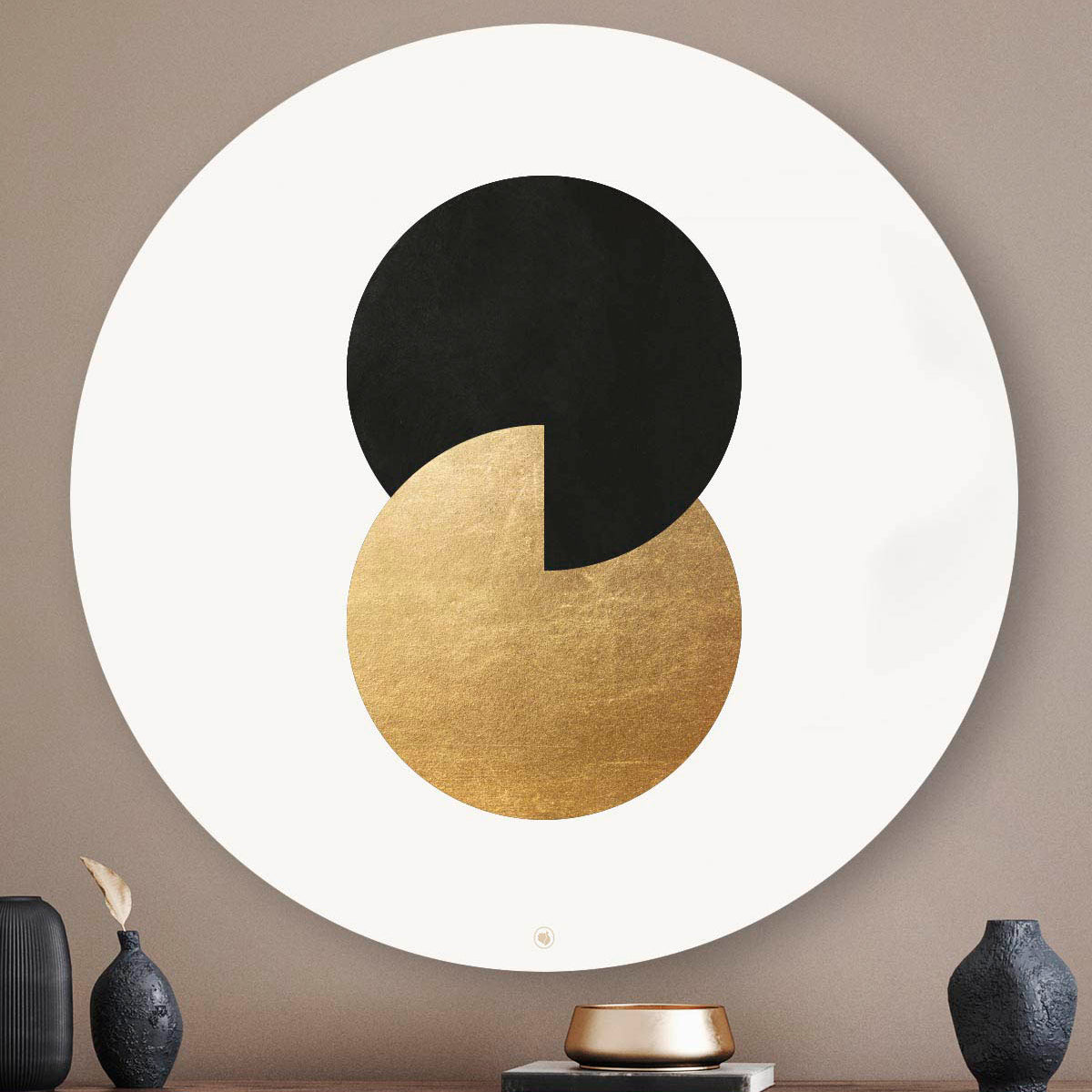 Muurcirkel met twee cirkels in het zwart en goud tegen een taupe muur