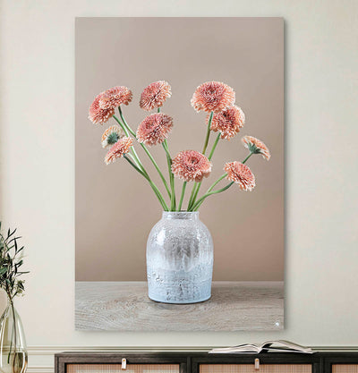 Schilderij met gerbera's en een grijze vaas tegen ene lichte muur en een japandi dressoir