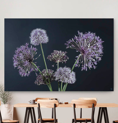 Wanddecoratie met paarse bloemen en een zwarte achtergrond tegen een muur