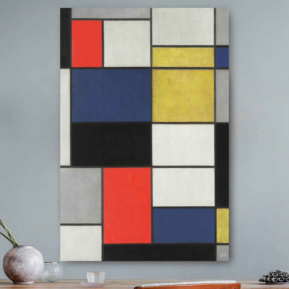 Mondriaan schilderij rood, geel, grijs, blauw, wit hangend aan de muur
