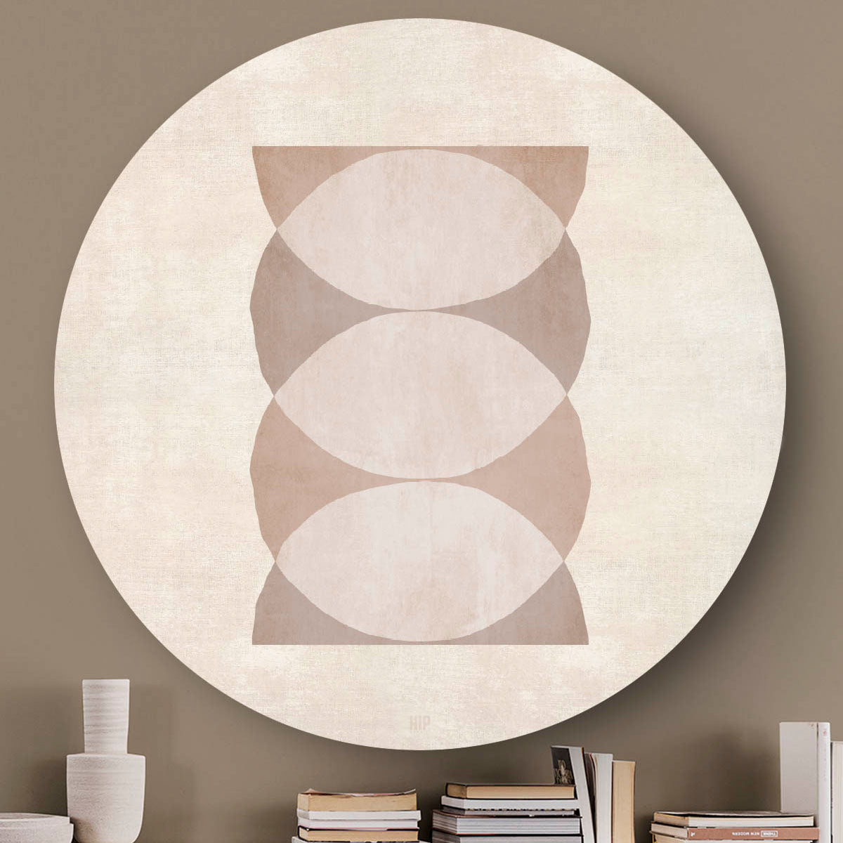 Wandcirkel met abstracte cirkels en een lichte achtergrond tegen een beige muur