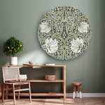 Wandcirkel groen met bloemenpatroon tegen een lichte muur en houten dressoir en stoel