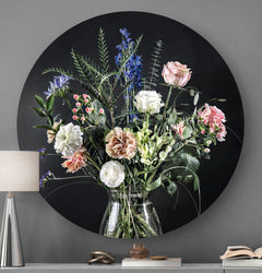 Voorzijde van wandcirkel met bloemen met zwarte achtergrond tegen een grijze muur