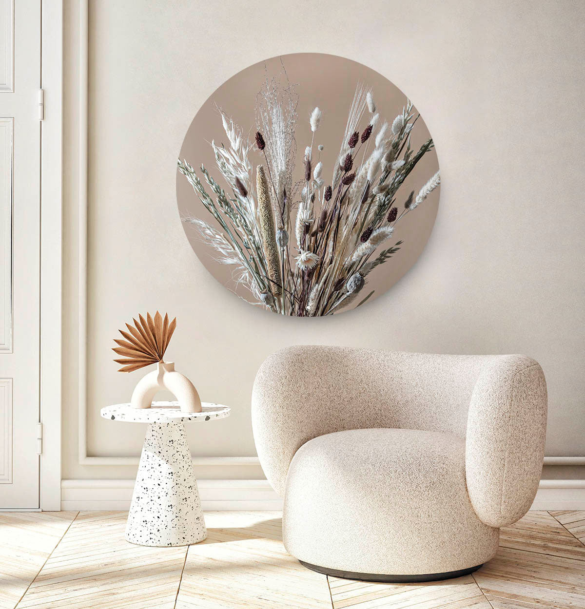 Wandcirkel met droogbloemen tegen een witte muur en een japandi stoel